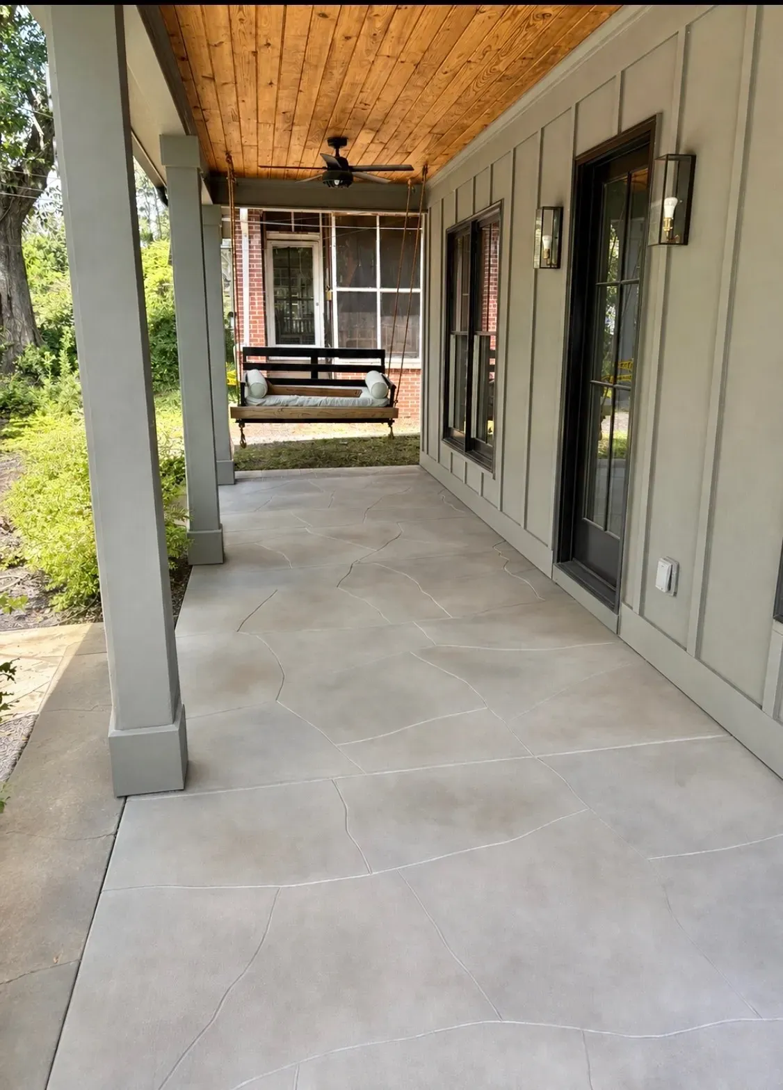 Stained concrete front porch with hand-cut flagstone pattern by JP Concrete Creations