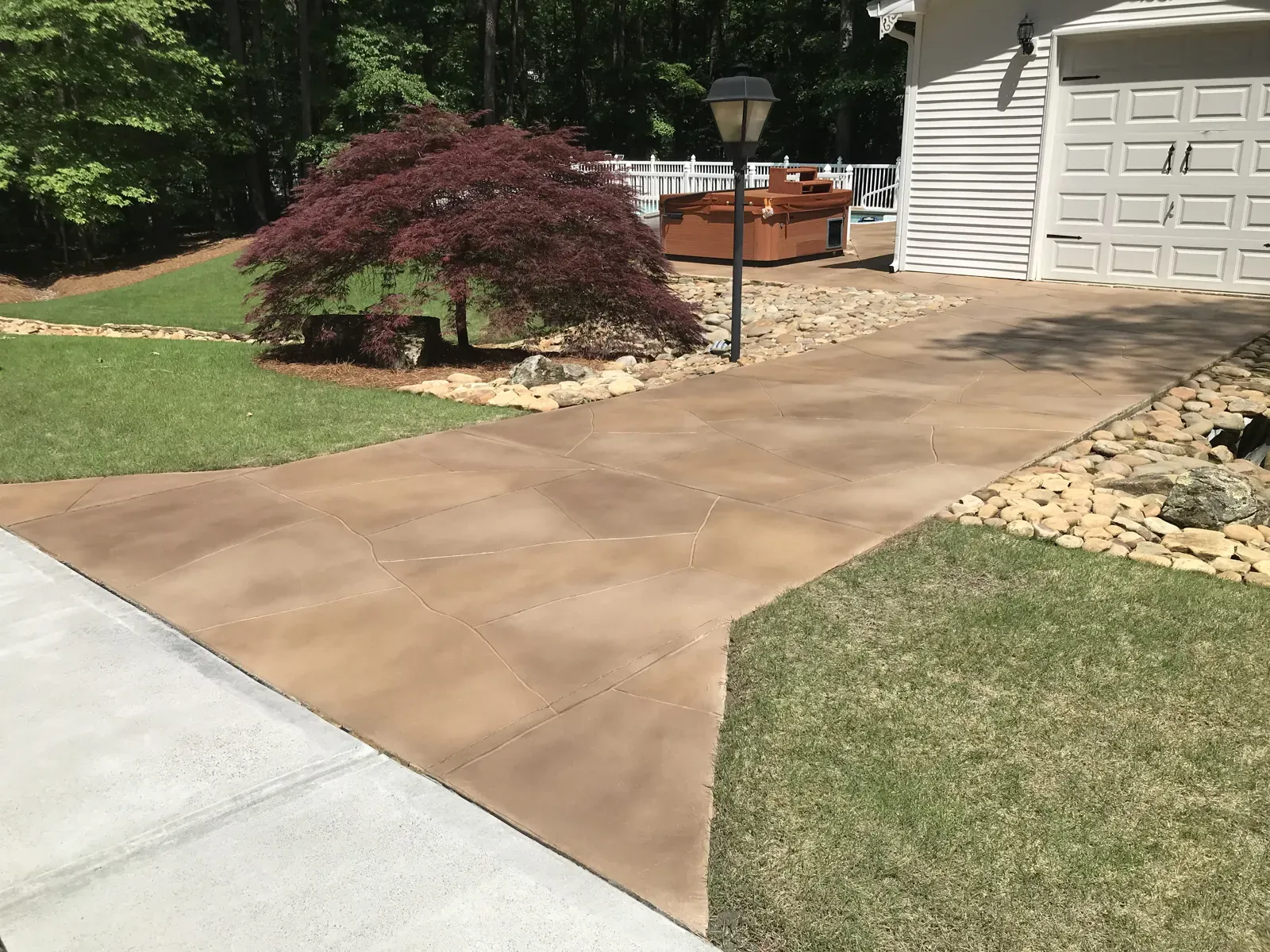 Resurfaced driveway and walkway with a warm tan decorative overlay at an Acworth GA home