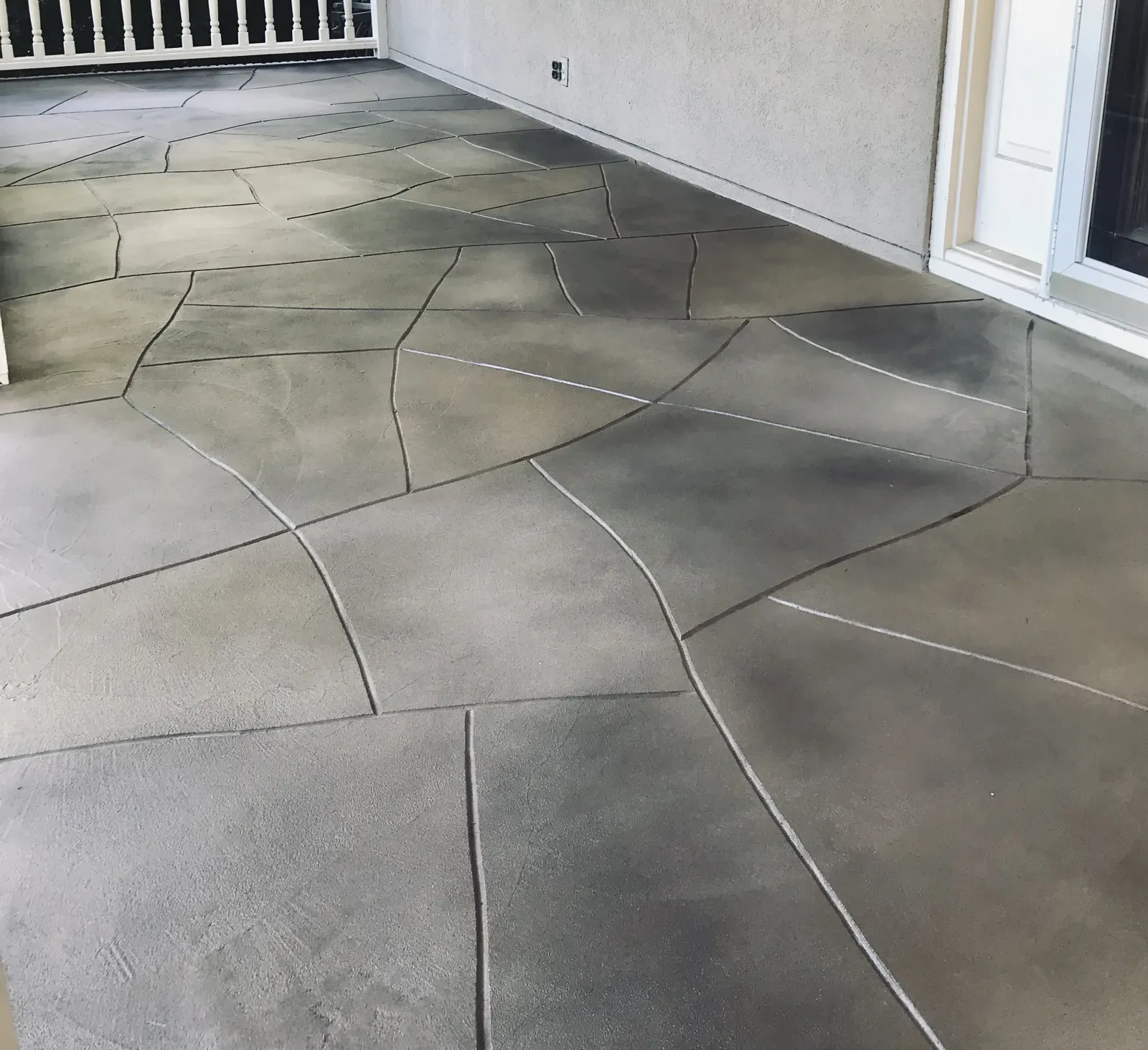 Stamped flagstone pattern concrete patio overlay in charcoal gray at a Dallas GA home