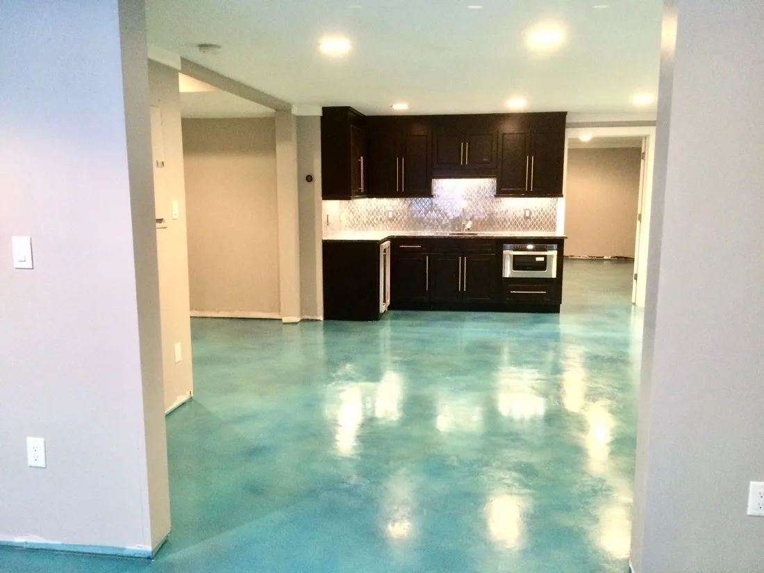 Bold teal stained concrete basement floor with a glossy finish by JP Concrete Creations near Kennesaw, Georgia
