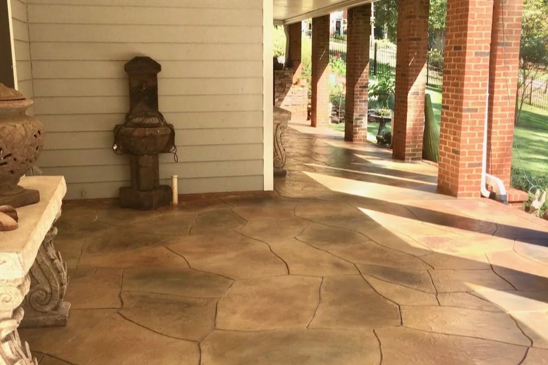 Covered patio resurfaced with a decorative flagstone-style stained concrete overlay in metro Atlanta