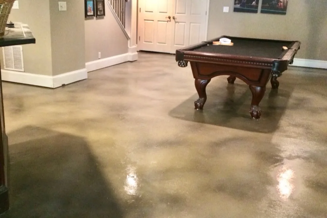Tan stained concrete basement floor with a soft satin sheen in a Georgia home game room